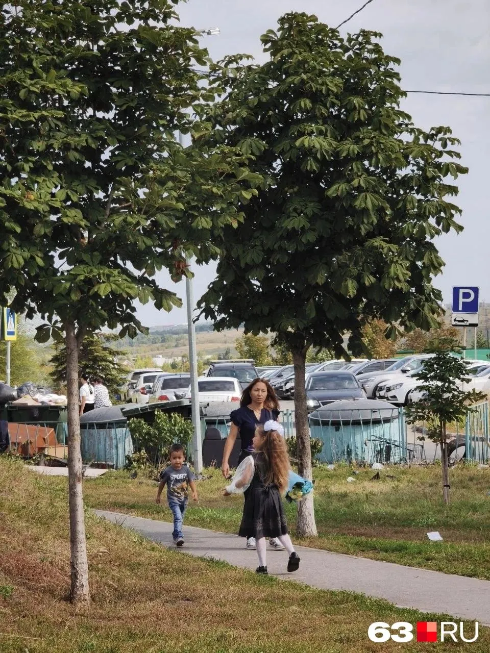 День знаний в городе: на улицах Самары царит праздничная атмосфера, школьники в нарядах и белых бантах, родители фиксируют моменты на фото.