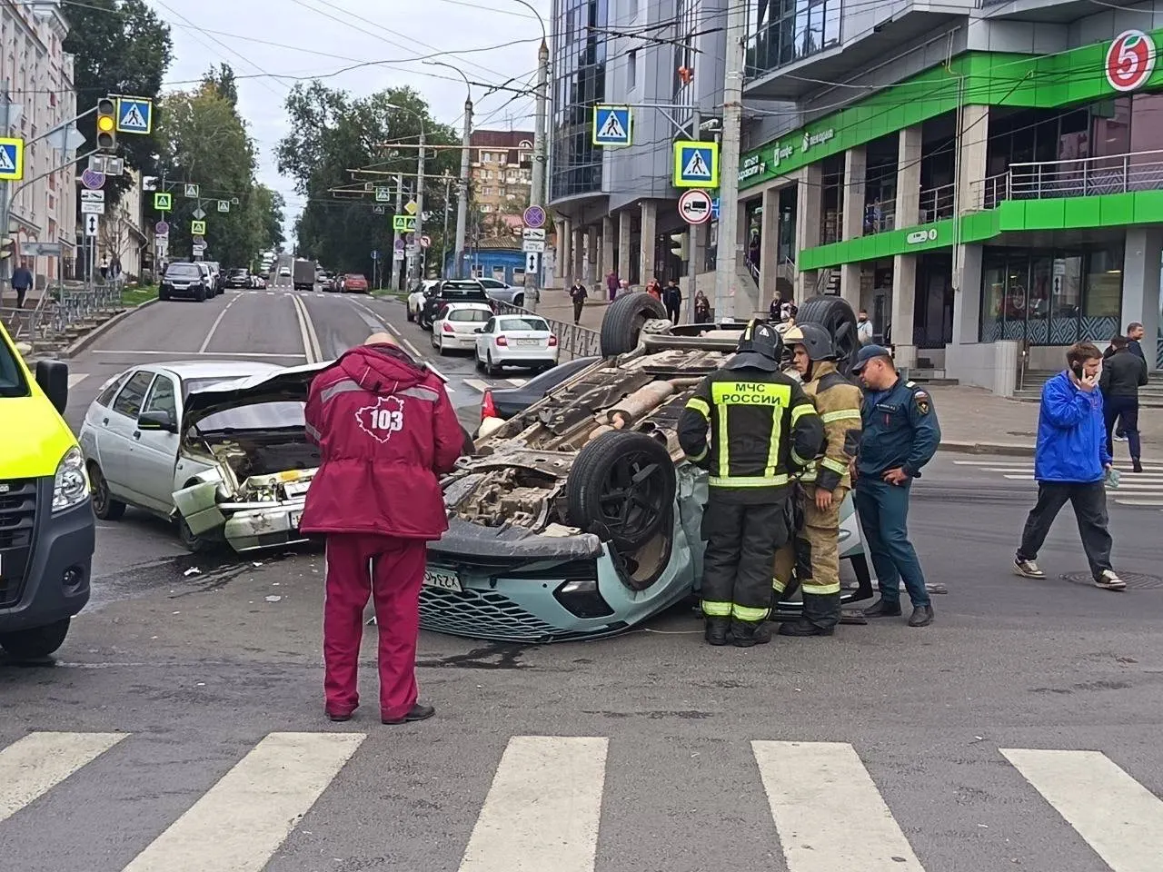 Столкновение между ВАЗ-2112 и каршеринговым автомобилем привело к опрокидыванию одного из машин; спасатели помогли людям выбраться из салонов.